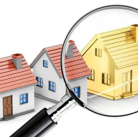 Magnifying glass searching houses to find the gold house