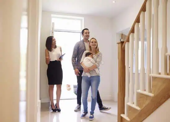 A young family and real estate agent looking around a home