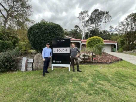 Sam Price, Brisbane Buyer's Agent and client standing outside a property just purchased. 