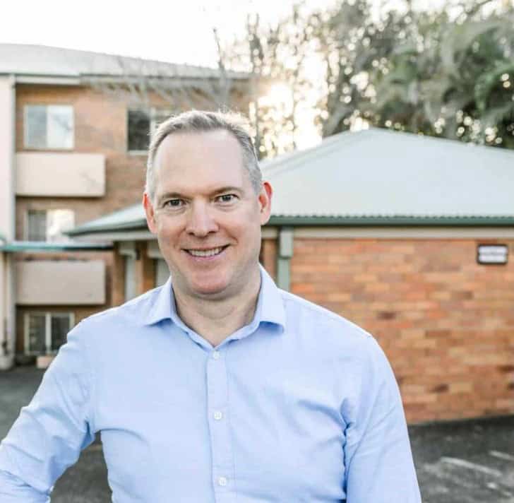 Sam Price, Brisbane Buyer's Agent, outside a low-maintenance brick unit block