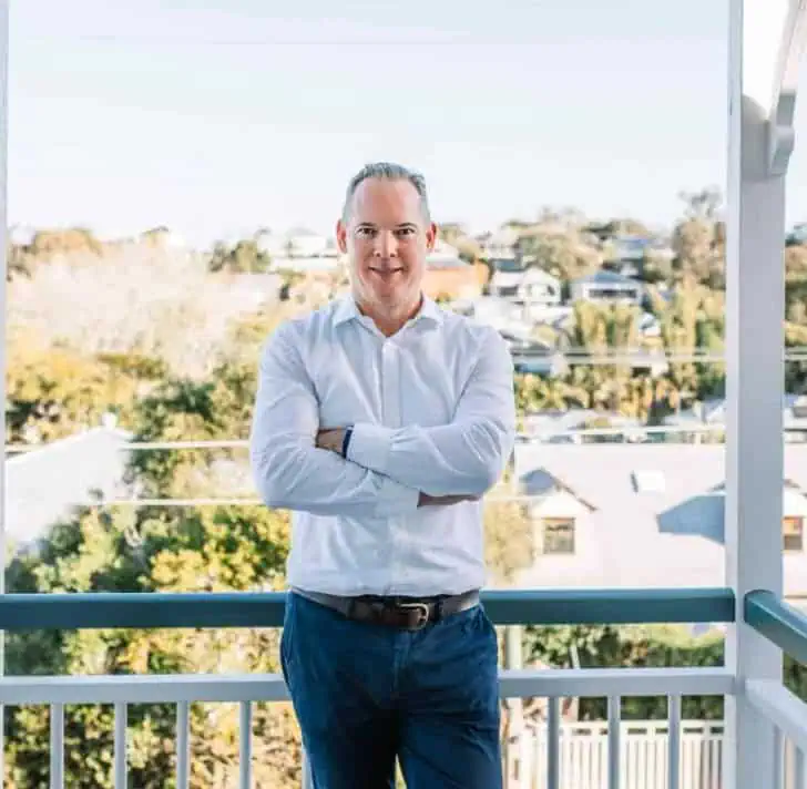 Sam Price, Brisbane Buyer's Agent, on a balcony overlooking Brisbane's inner west